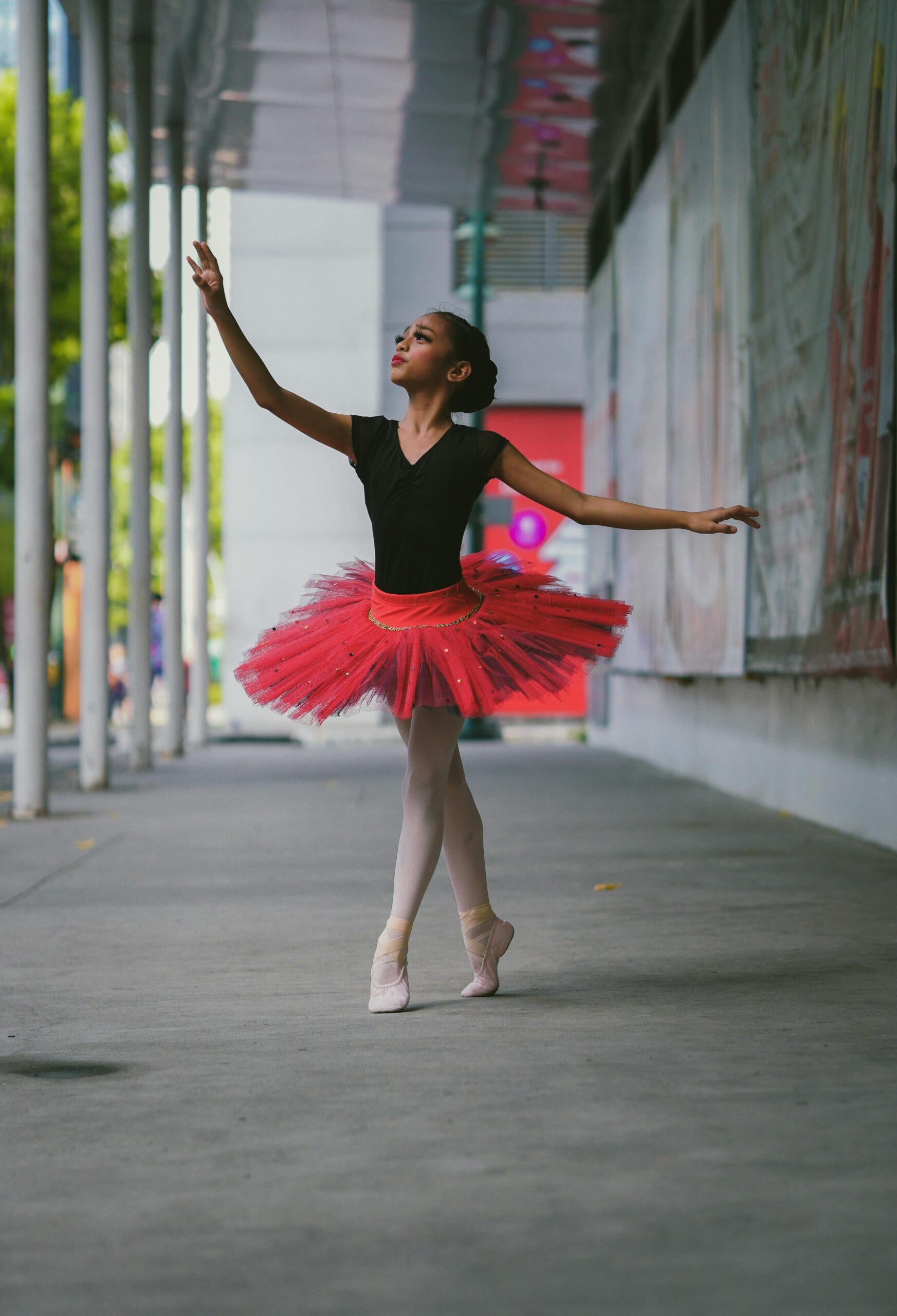 A graceful ballet dancer performs outdoors in a vibrant tutu, showcasing elegance and poise.